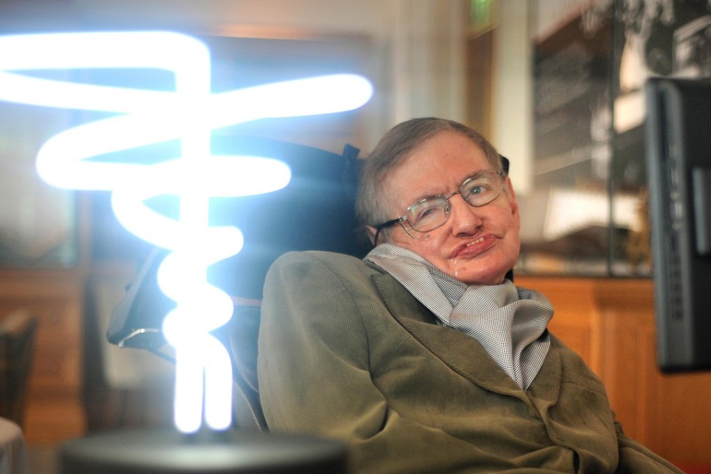 In this February 25, 2012 photo, Professor Stephen Hawking poses beside a lamp titled “black hole light” by inventor Mark Champkins, presented to him during his visit to the Science Museum in London. Photo: AP