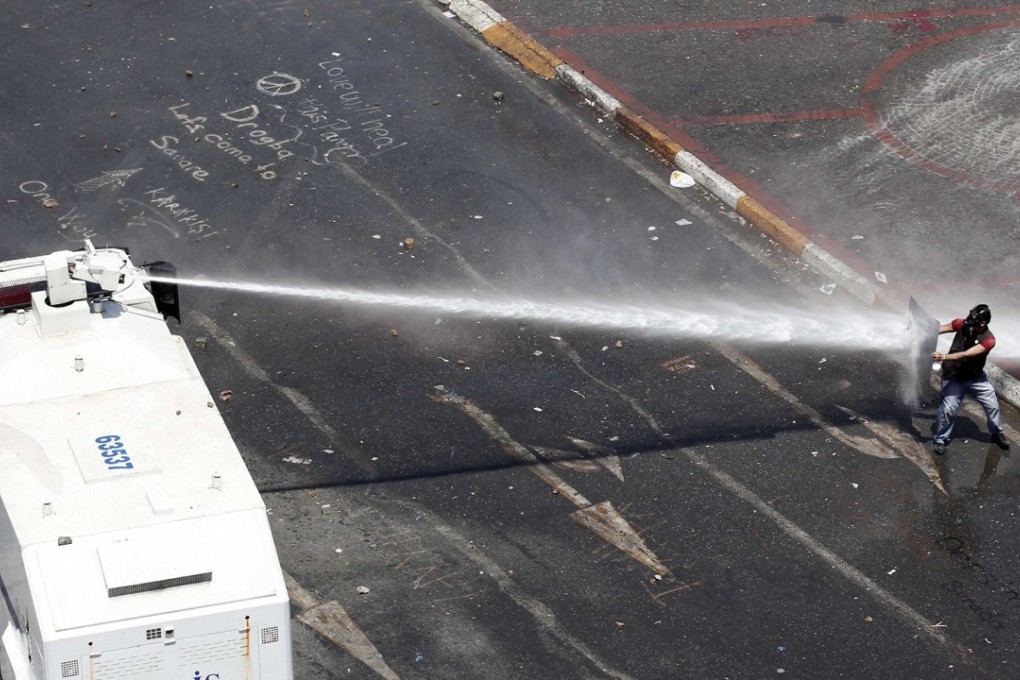 A protester uses a shield to block water cannon during clashes in Istanbul’s Taksim Square in 2013. Photo: Reuters