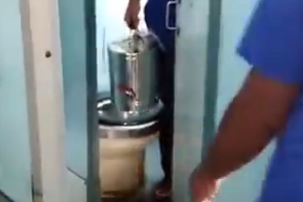 An Indian tea vendor taking a large can out of a toilet. Photo: Twitter