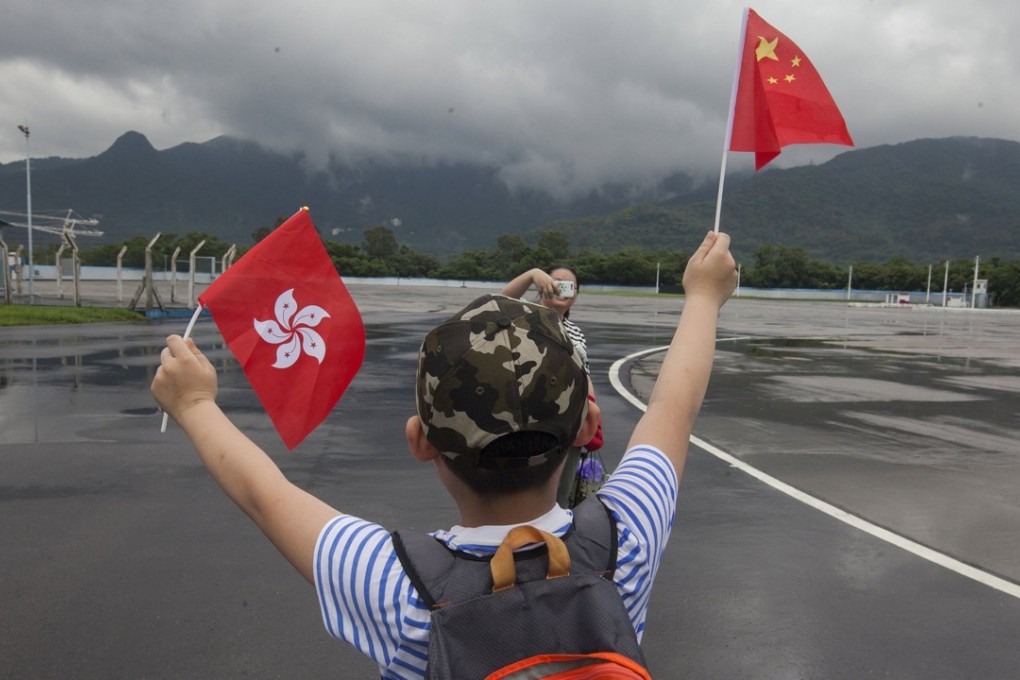 A child waves a Hong Kong flag and the national flag at the PLA Shek Kong barracks during the PLA open day in July last year. The People’s Liberation Army controls 2,700 hectares of land in Hong Kong, much of it underutilised. Photo: EPA