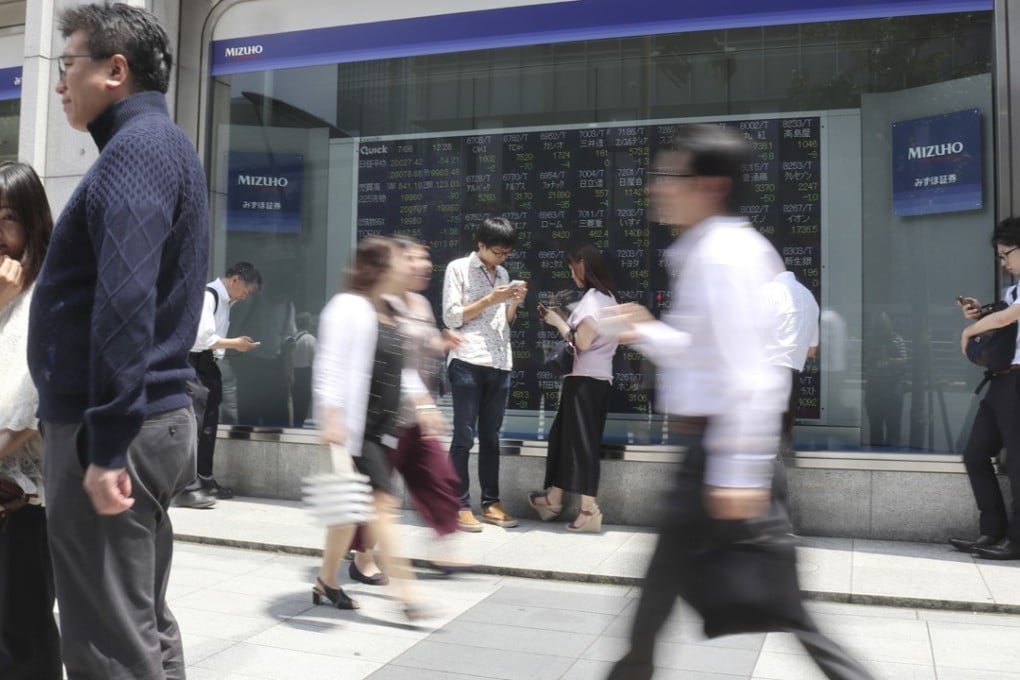 An electronic stock indicator at a securities company in Tokyo. The BOJ holds more than 75 per cent of exchange-traded funds and 45 per cent of government debt. Photo: AP