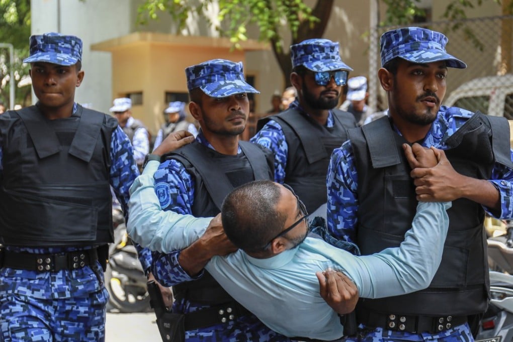 Maldivian police remove an opposition member who tried to enter a Parliament building that closed following the state of emergency. Photo: AP
