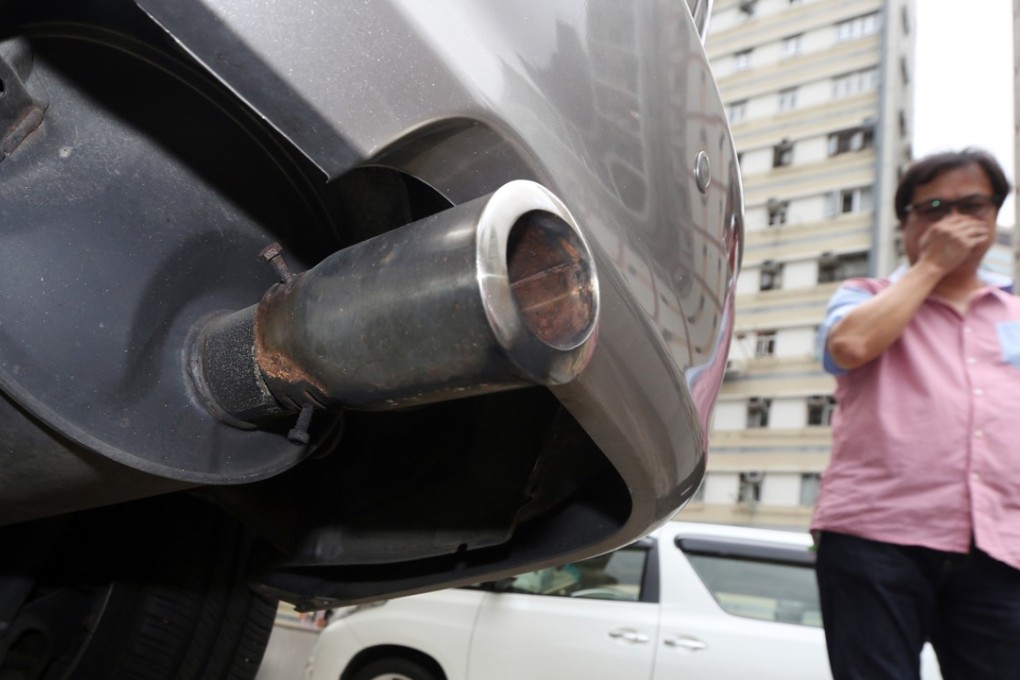 A man walks past a car with an idling engine, in Causeway Bay in 2015. Photo: Felix Wong