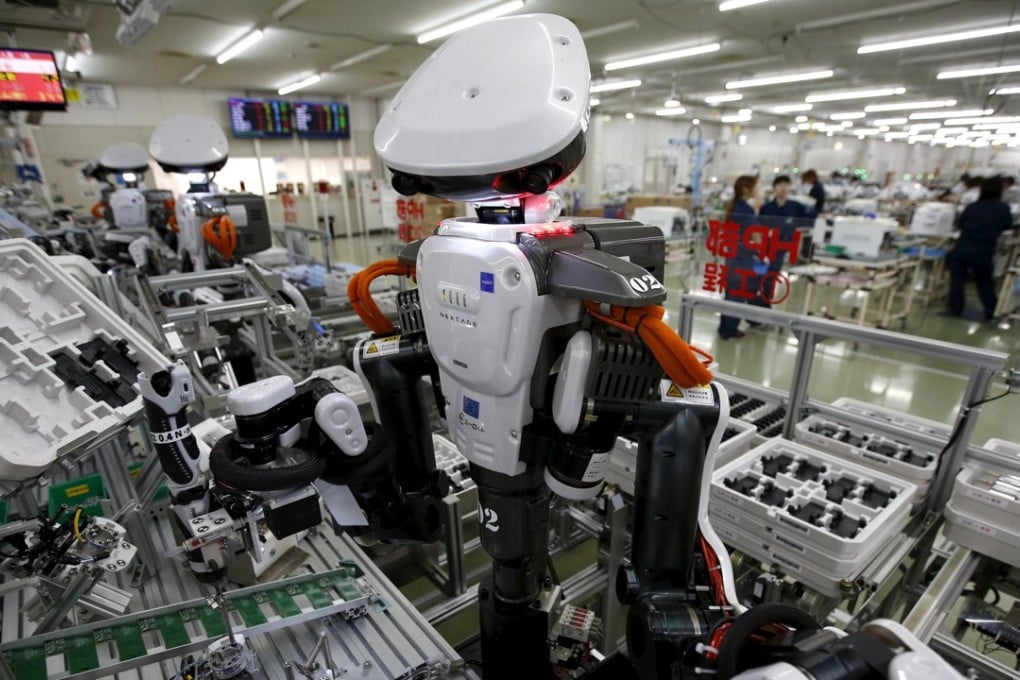 Humanoid robots work side by side with employees in the assembly line at a factory of Glory Ltd., a manufacturer of automatic change dispensers, in Kazo, north of Tokyo, Japan. Photo: REUTERS/Issei Kato