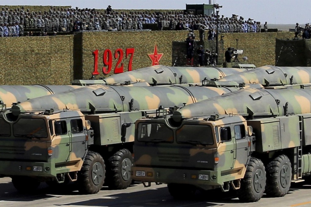 In this photo released by China's Xinhua News Agency, military vehicles carrying missiles for both nuclear and conventional strikes are driven past the VIP stage during a military parade to commemorate the 90th anniversary of the founding of the People's Liberation Army at Zhurihe training base in north China's Inner Mongolia Autonomous Region, Sunday, July 30, 2017. China's military has the "confidence and capability" to bolster the country's rise into a world power, President Xi Jinping said Sunday as he oversaw a large-scale military parade meant to show off the forces at his command to foreign and domestic audiences. (Zha Chunming/Xinhua via AP)