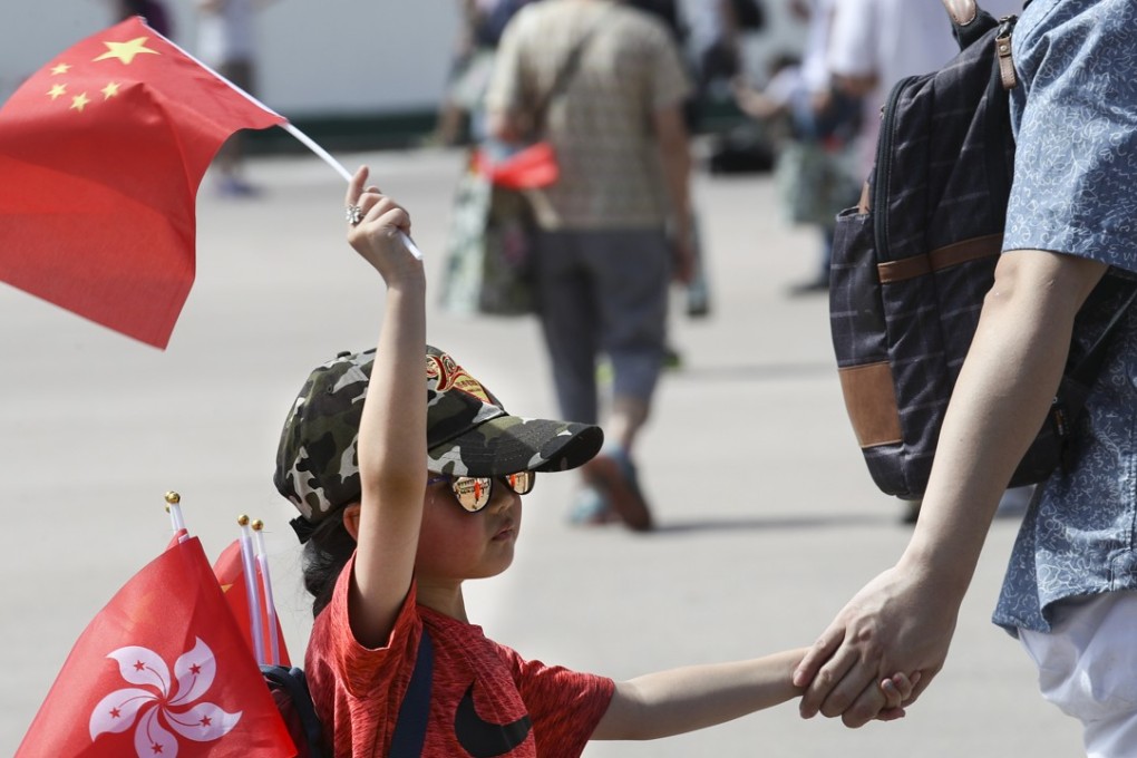 A young visitor flies the flags for Hong Kong and mainland China, during a trip to the People’s Liberation Army barracks in Sha Tau Kok, on July 9, 2017. Photo: Nora Tam