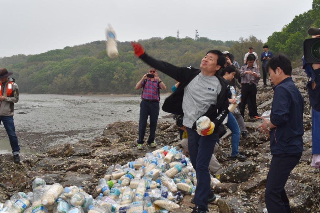 Park Jeong-ho launches a bottle into the Yellow Sea near the North Korean border. Photo: John Power