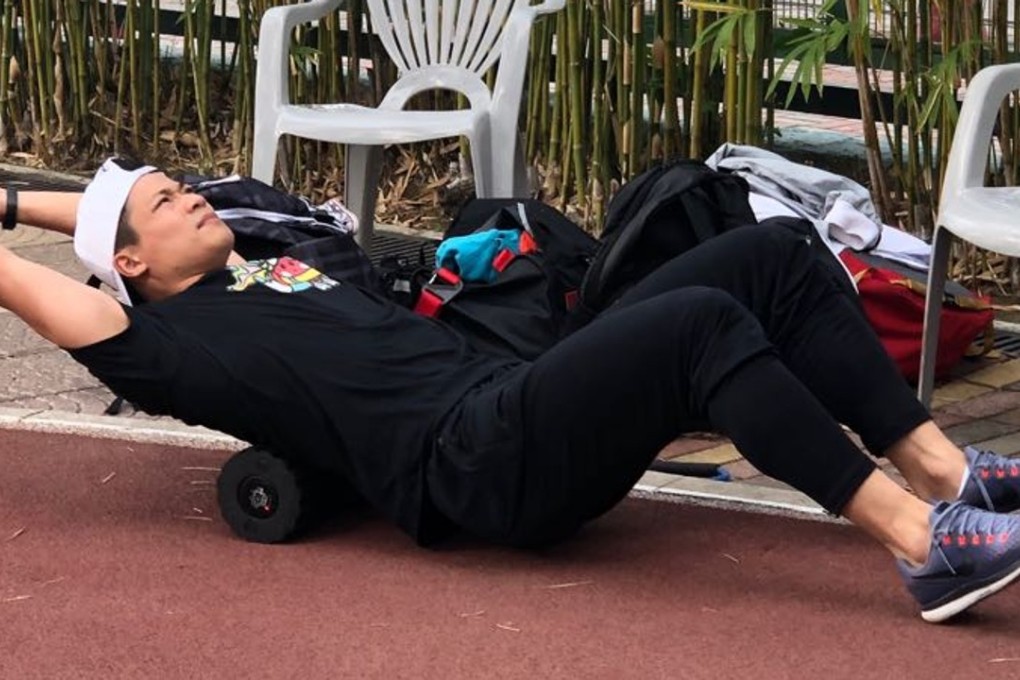 Su Bingtian performs some stretching exercises at the Wan Chai Sports Ground as he prepares for his race at the Hong Kong Championships on Sunday. Photo: Chan Kin-wa