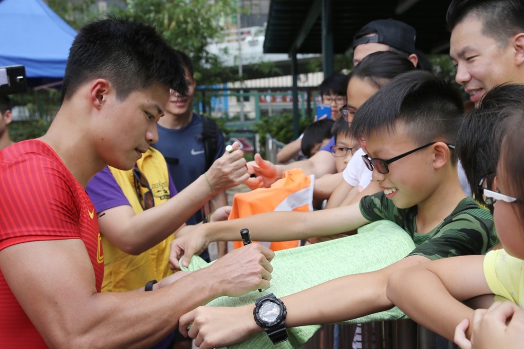 Su Bingtian takes time out to sign autographs for his adoring fans at Wan Chai Sports Ground. Photo: Sam Tsang