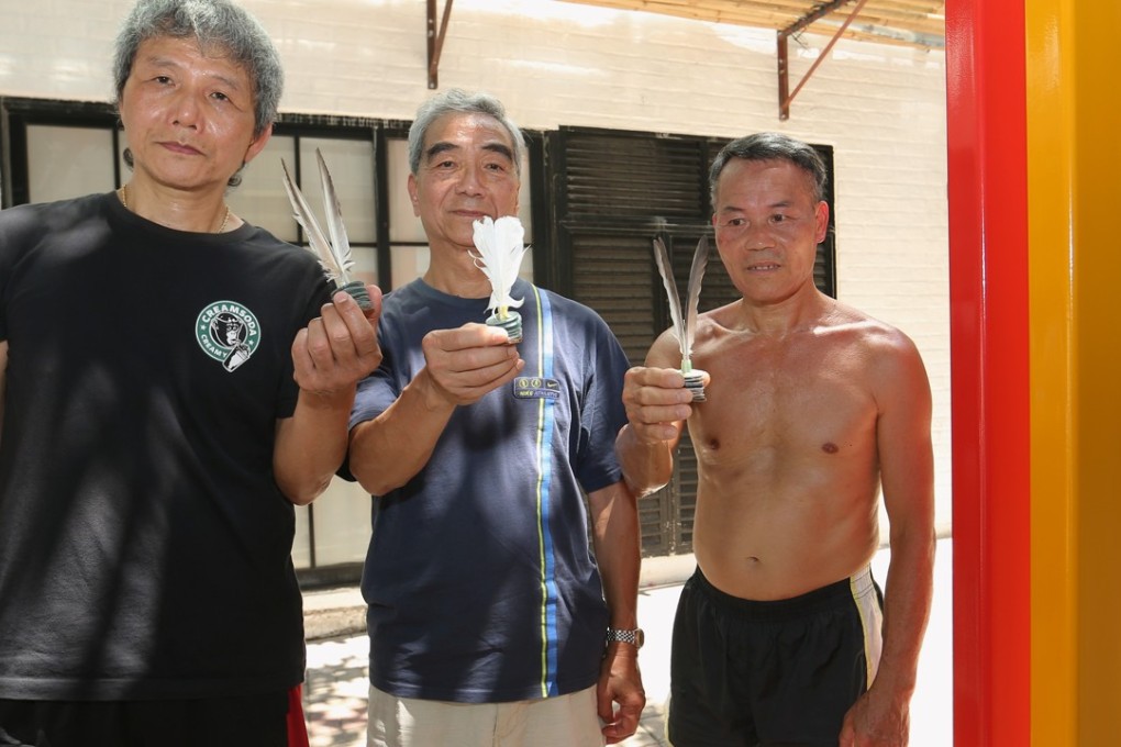 Players of popular lunchtime shuttlecock game (From left) Ah Wing, Tommy Tse and Chan Hung-fat with an artwork that some say has obstructed their space. Photo: Edmond So