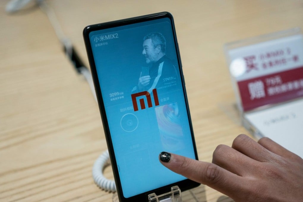 A customer looks at a Xiaomi smartphone in a shop in Beijing. The Chinese smartphone maker has kicked off what is expected to be the world's biggest IPO in years after it filed an application with Hong Kong's stock exchange. Photo: AFP