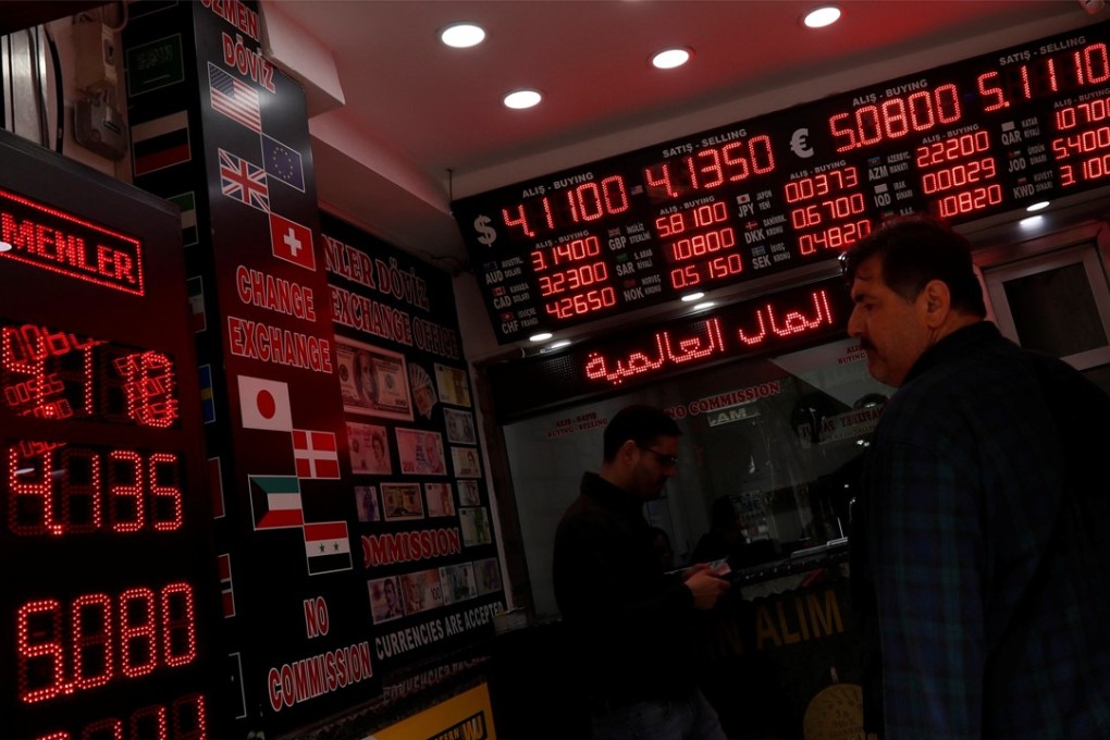A man checks rates at a currency exchange office in Istanbul, Turkey, on April 11. The lira fell to a record low against the US dollar last week. Photo: Reuters