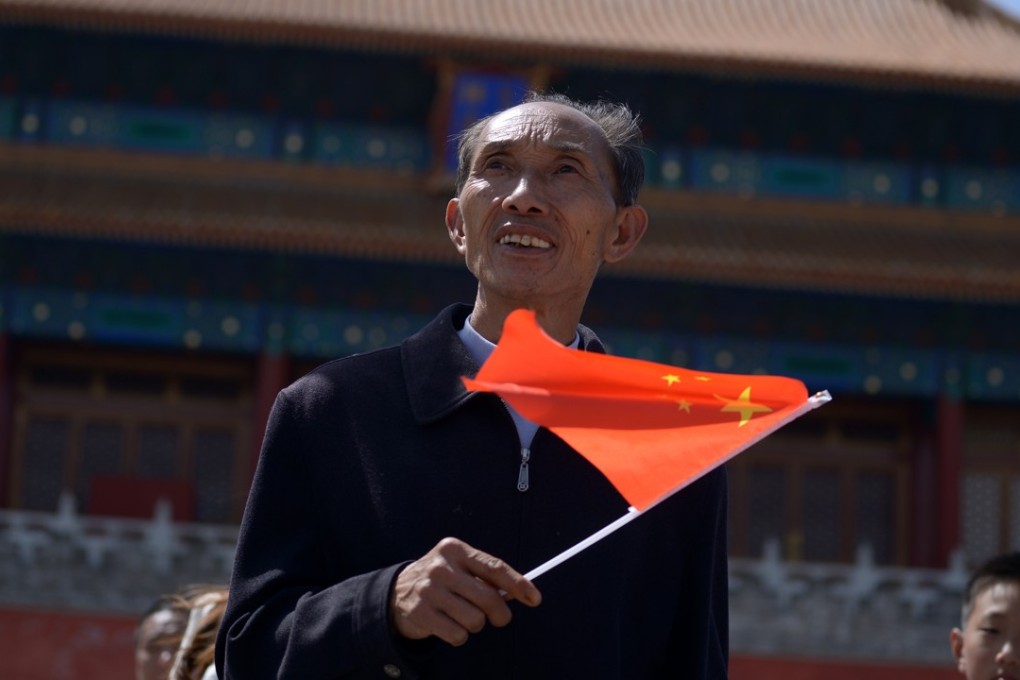A man waves a Chinese flag after visiting the Forbidden City in Beijing in May 2015. Photo: AFP
