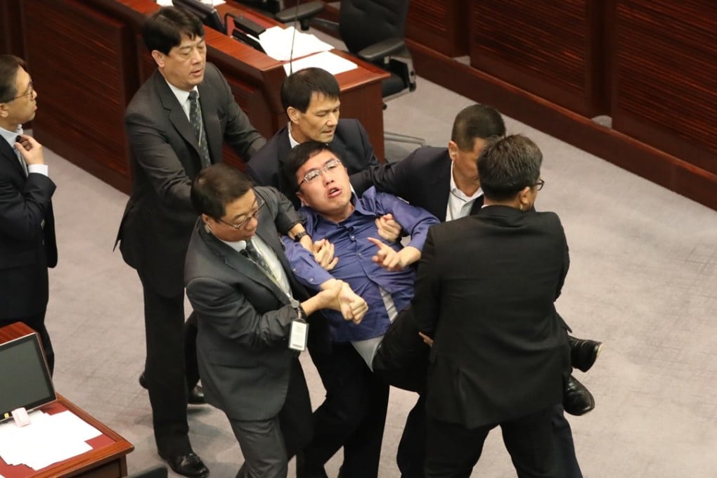 Security personnel at Legco remove Au from the chamber. Photo: Edward Wong
