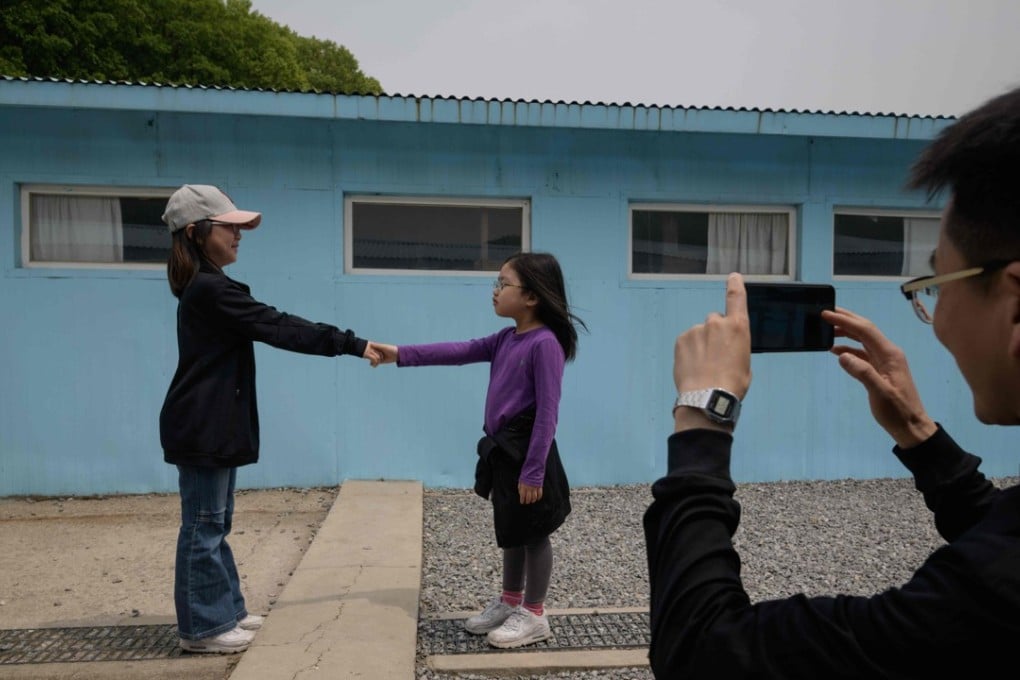 Two young girls recreate the handshake between South Korean leader Moon Jae-in and the North’s leader Kim Jong-un at a film set depicting the DMZ border truce village of Panmunjom. Photo: AFP