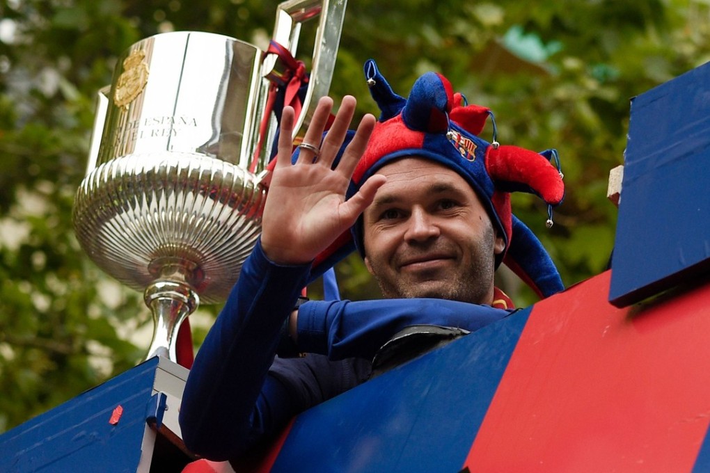 Barcelona’s Spanish midfielder Andres Iniesta waves from an open-top bus as the team parade to celebrate their 25th La Liga title in Barcelona. Photo: AFP