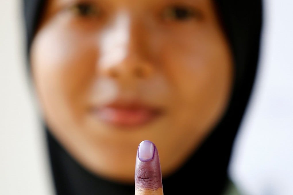 A Malaysian military officer shows her finger marked with indelible ink after casting her ballot during the early voting at Kementah Camp in Kuala Lumpur. Photo: Reuters
