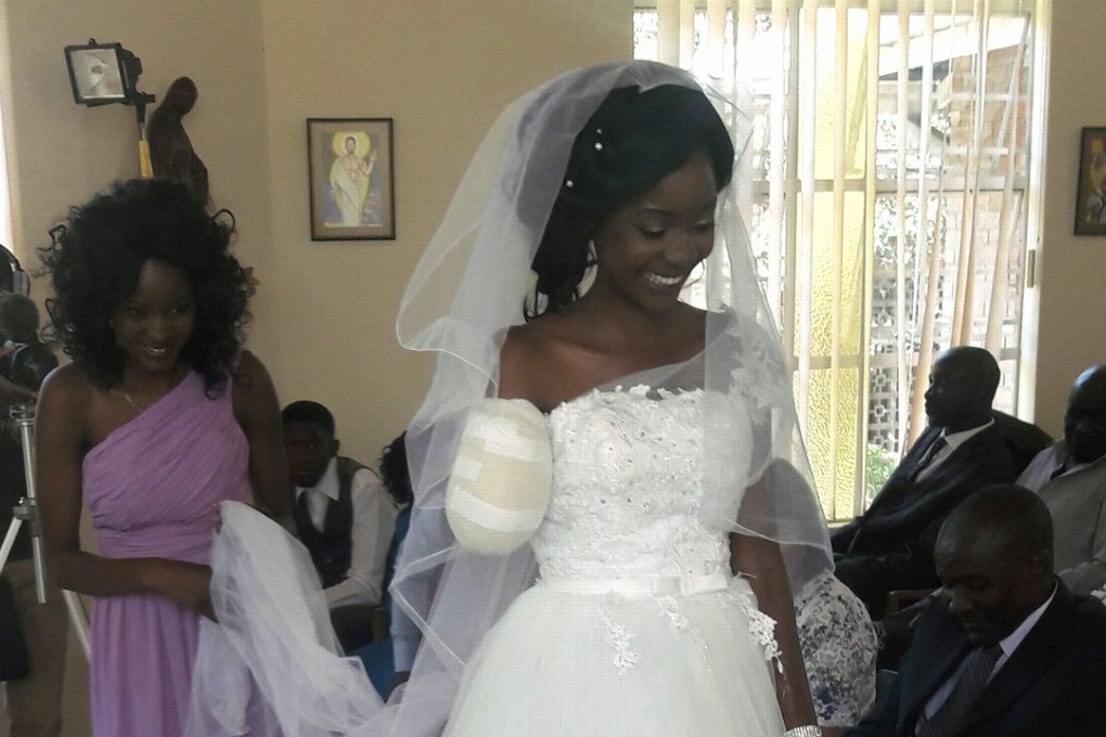 In this photo taken on Saturday, Zenele Ndlovu walks down the aisle on her wedding day at a hospital Chapel in Bulawayo, Zimbabwe. A bandage covers the remains of her right arm, which was bitten off by a crocodile last week. Photo: AP
