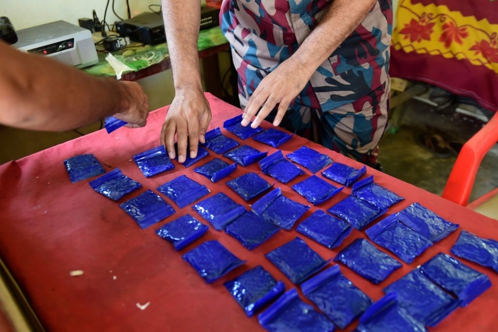Bangladesh Border Guard (BGB) personnel lay out small bags of the drug ‘yaba’ recovered from a bus. Photo: AFP