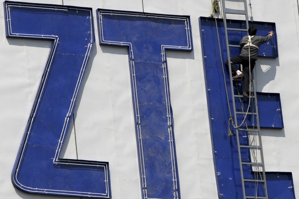 A worker installs a ZTE logo onto a building in Nanjing in eastern China's Jiangsu province in April 2001. ZTE has ceased many major operations after it was hit with a US ban stopping sales of parts to the company, a source told the ‘South China Morning Post’. Photo: Chinatopix Via AP