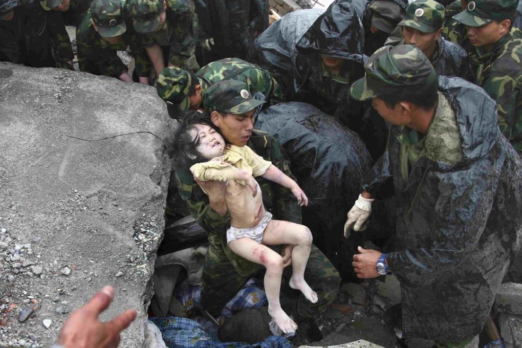 Soldiers rescue a child from the rubble after the magnitude-8 earthquake in Beichuan, Sichuan province May 13, 2008. Photo: Reuters