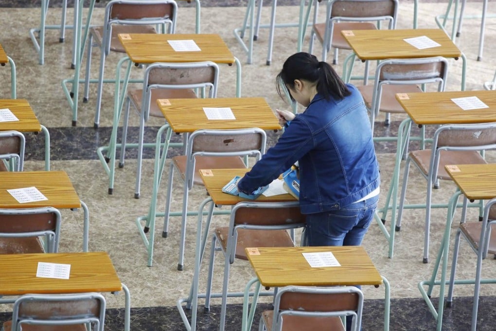 An invigilator arranges papers before the DSE exam at Kiangsu-Chekiang College in North Point, on April 9. Photo: Handout