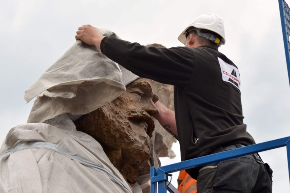 A worker covers the statue of German philosopher, economist, political theorist and sociologist Karl Marx in Trier, Germany. The bronze statue created by Chinese artist Wu Weishan weighs 2.3 tonnes. Photo: AFP