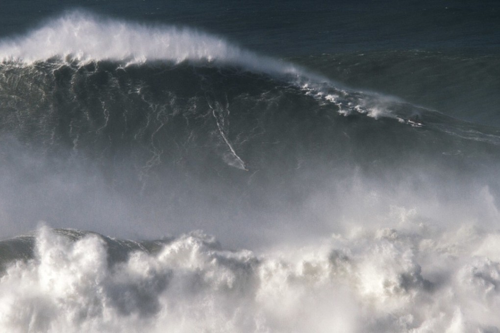 In this photo taken November 8 2017, Brazilian surfer Rodrigo Koxa rides what has been judged the biggest wave ever surfed, 24.38 metres at the Praia do Norte, or North beach, in Nazare, Portugal. A more-scientifically measured wave that was 23.8 metres high has been declared the biggest wave ever recorded in the Southern Hemisphere. Photo: AP