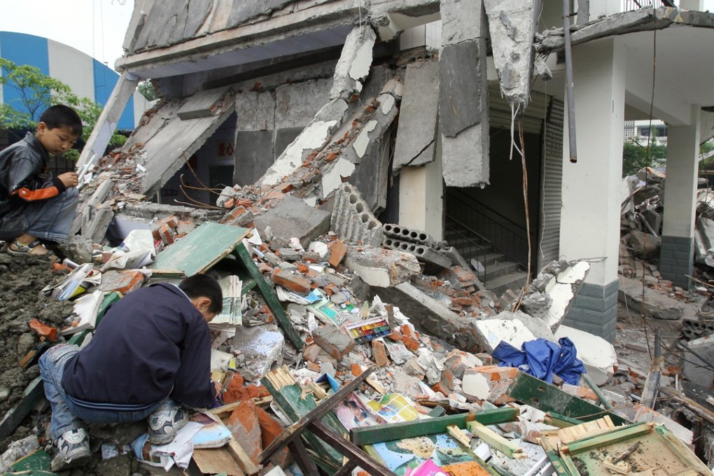 Two boys sift through the ruins of a Dujiangyan secondary school flattened by the May 12 earthquake. Robert Ng