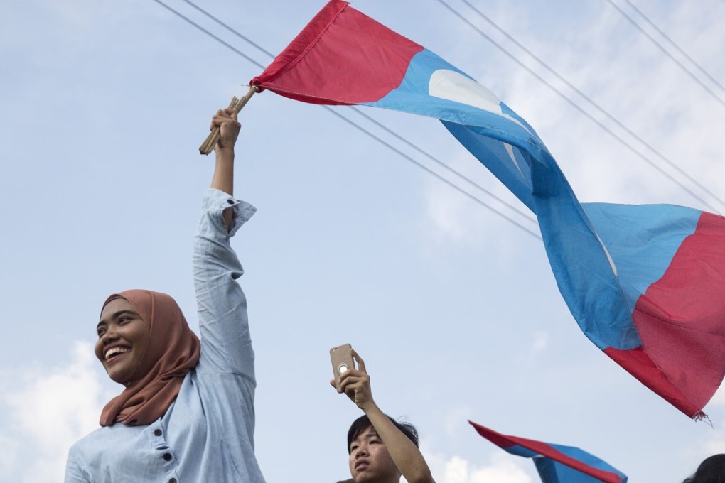 A Malaysian woman waves a Pakatan Harapan flag in Kuala Lumpur. Photo: Bloomberg