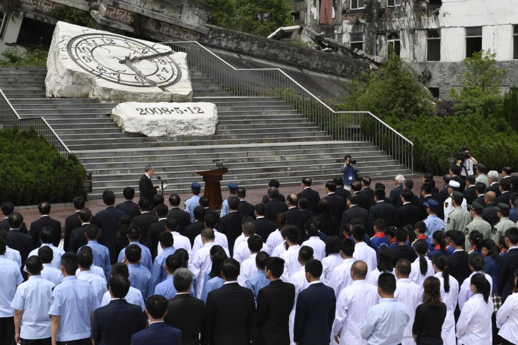 An official ceremony is held outside the Xuankou Middle School, which is now a memorial site where the hands of a broken clock are frozen at 2.28pm – the time the earthquake struck. Photo: Xinhua
