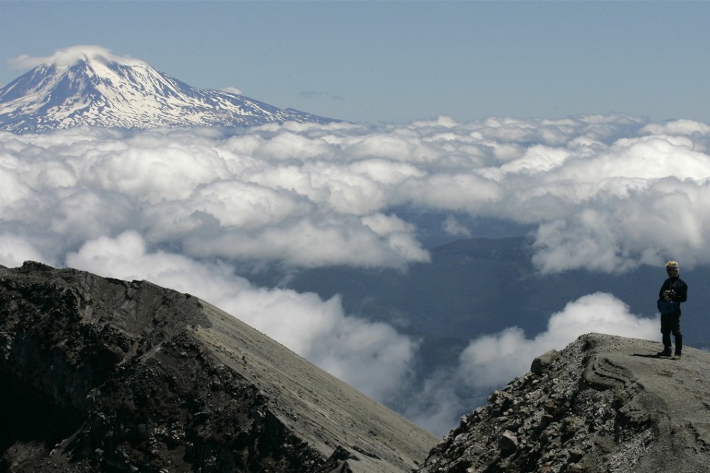 A man stands on the crater rim of Mount St. Helens, with Mount Adams in the background, in 2006. The 2018 eruption of the Kilauea volcano in Hawaii has created concerns that US West Coast volcanoes, including St. Helens, and Adams, could also erupt. Photo: AP