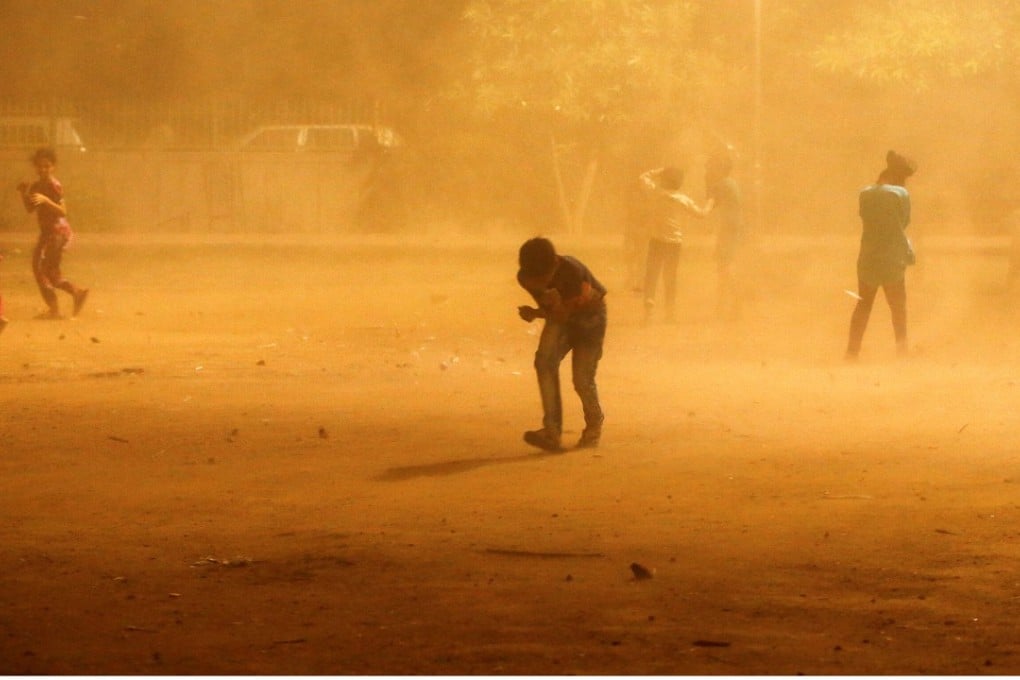 Children run for cover during a powerful dust storm in New Delhi, India on May 13, 2018. Photo: Reuters