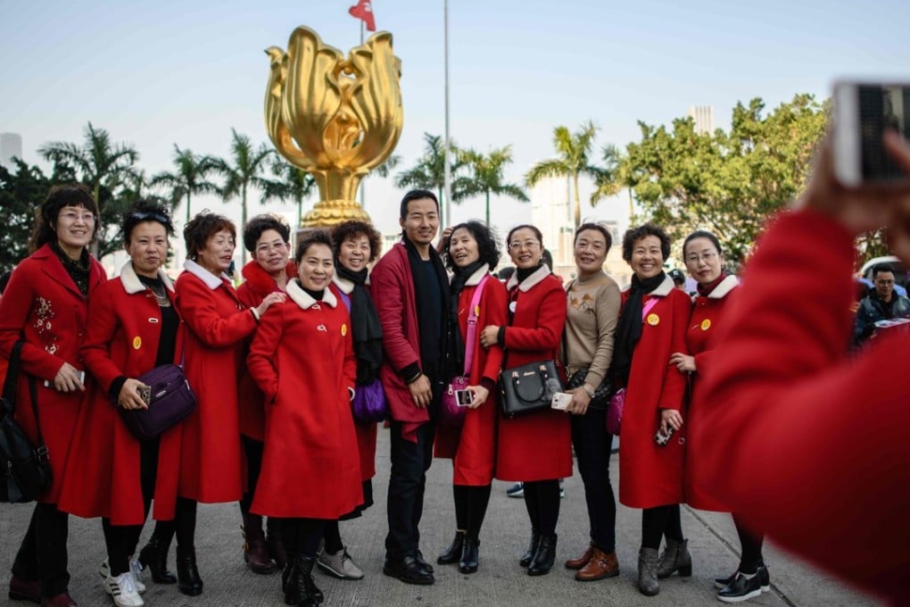 Tourists from mainland China pose for photos in front of the Golden Bauhinia statue, a gift from the central government to Hong Kong in 1997 to celebrate the city’s return to Chinese sovereignty, in Wan Chai in December 2017. Photo: AFP