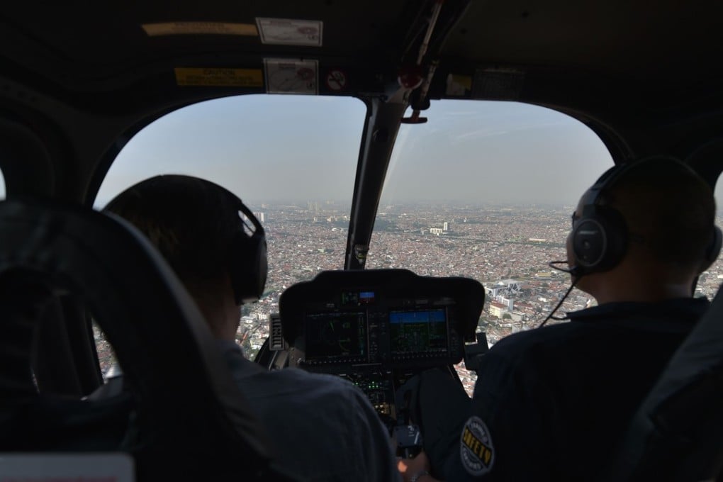 A Helicity helicopter takes passengers over Jakarta after receiving an order from a smartphone app. Photo: AFP