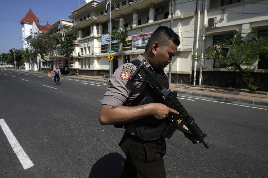 Officers block the road outside a local police headquarters following Monday’s attack in Surabaya. Photo: AP