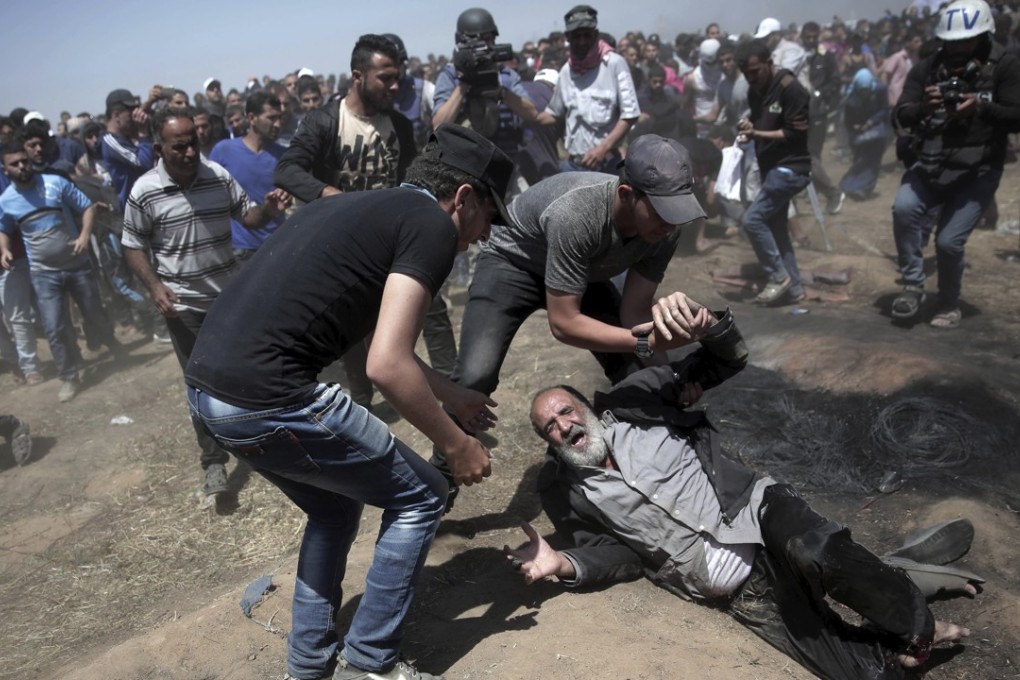 An elderly Palestinian man falls on the ground after being shot by Israeli troops during a deadly protest at the Gaza Strip's border with Israel on Monday. Photo: AP