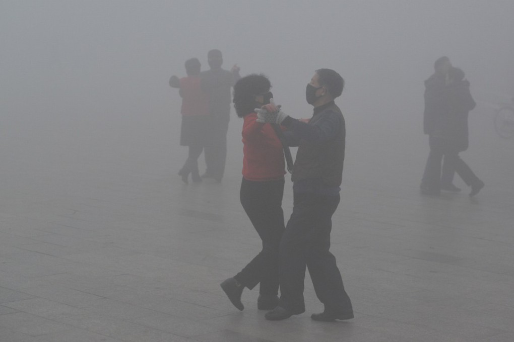 A couple wearing face masks dance during heavy smog in Fuyang in Anhui province. Photo: Reuters