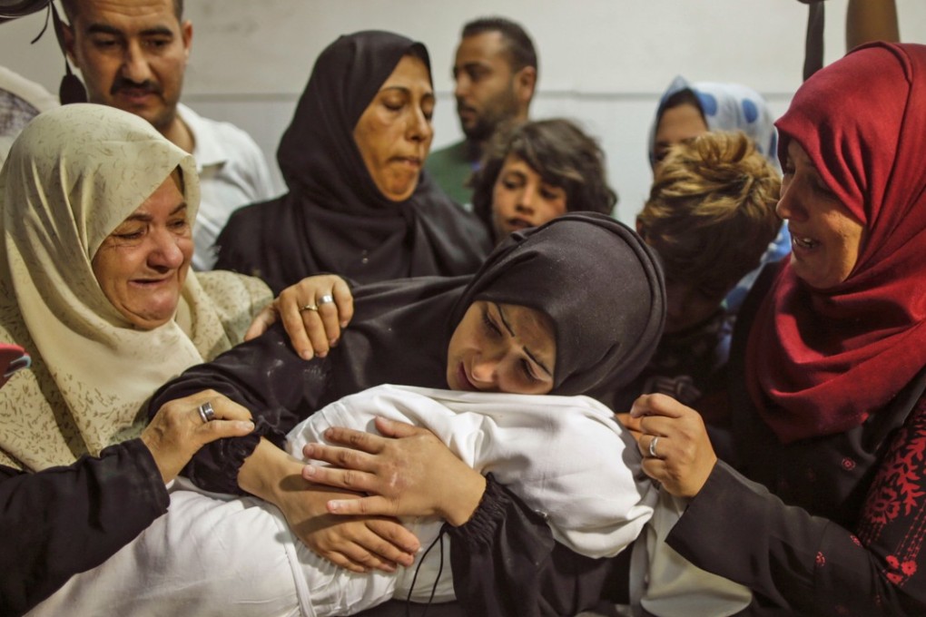 The mother of a Leila al-Ghandour, the Palestinian baby who according to the Palestinian health ministry died during clashes in East Gaza the previous day, holds her at the morgue of al-Shifa hospital in Gaza City. Photo: AFP