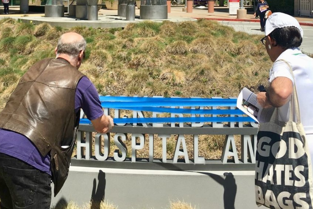Protesters cover up the word "Zuckerberg" in the sign for Zuckerberg San Francisco General Hospital. Photo: Sasha Cuttler/Business Insider