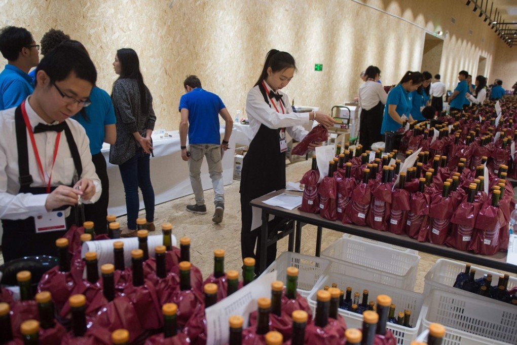 Waiters take wine bottles to be tested by expert judges during the 2018 Concours Mondiale de Bruxelles at a luxury hotel in Beijing on May 11. Photo: AFP