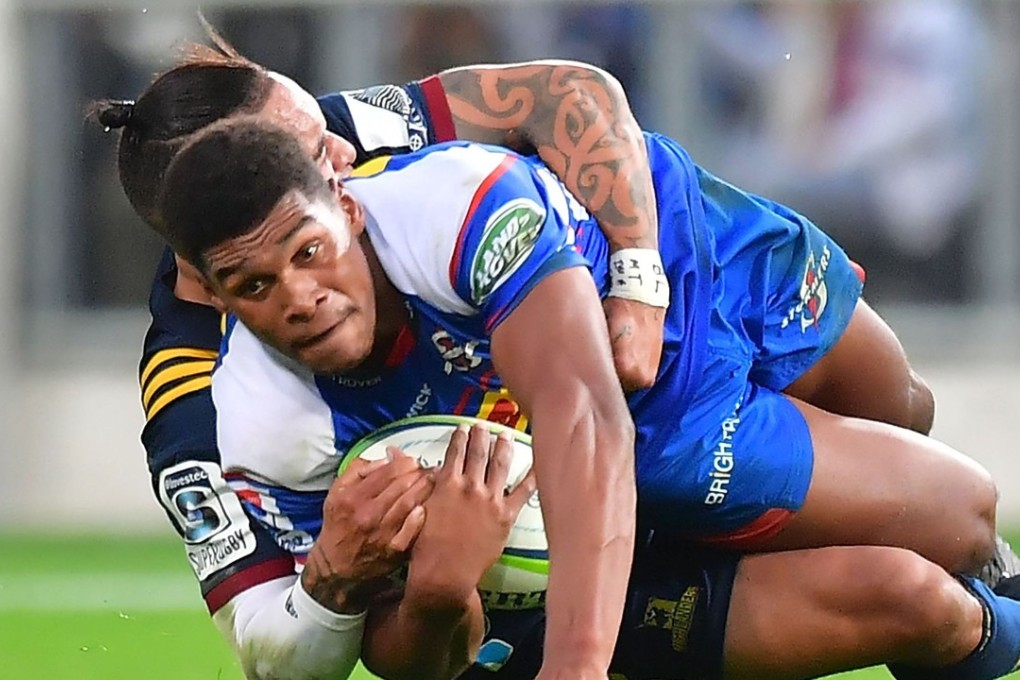 Stormers’ star Damian Willemse is tackled by Highlanders’ scrum half Aaron Smith. Photo: AFP
