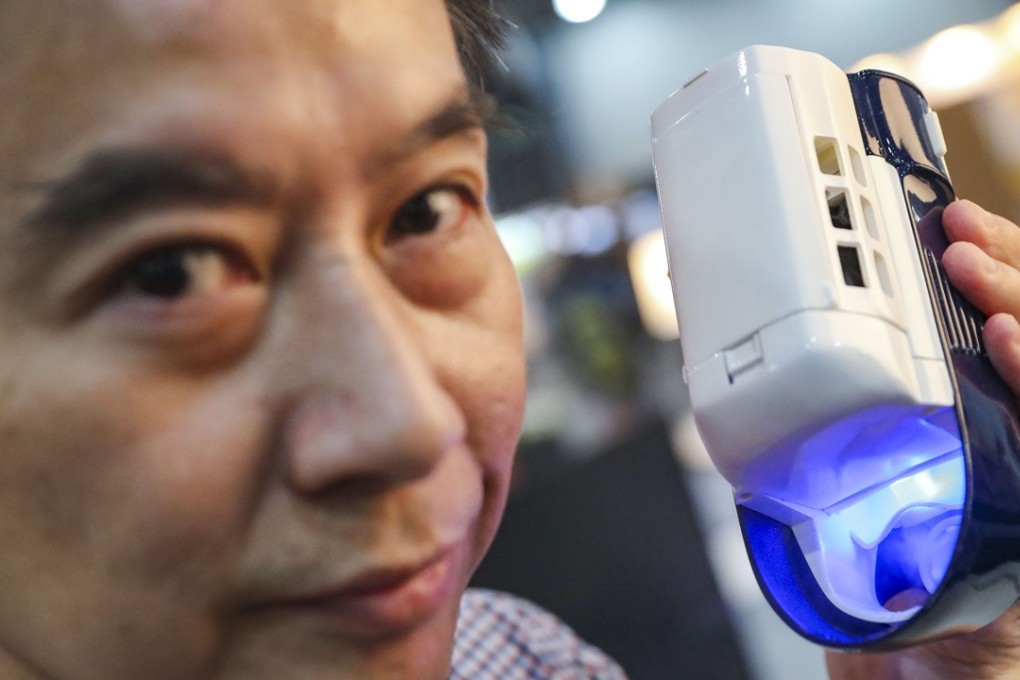 Kascien Chan, director of Hi-Cooler, shows off his company’s hand-held air conditioner. Photo: K.Y. Cheng