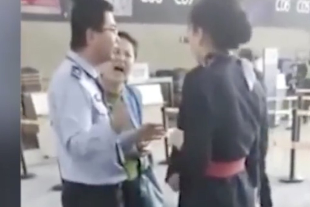 The woman, centre, was filmed shouting at the airline worker as security staff attempted to intervene. Source: PearVideo