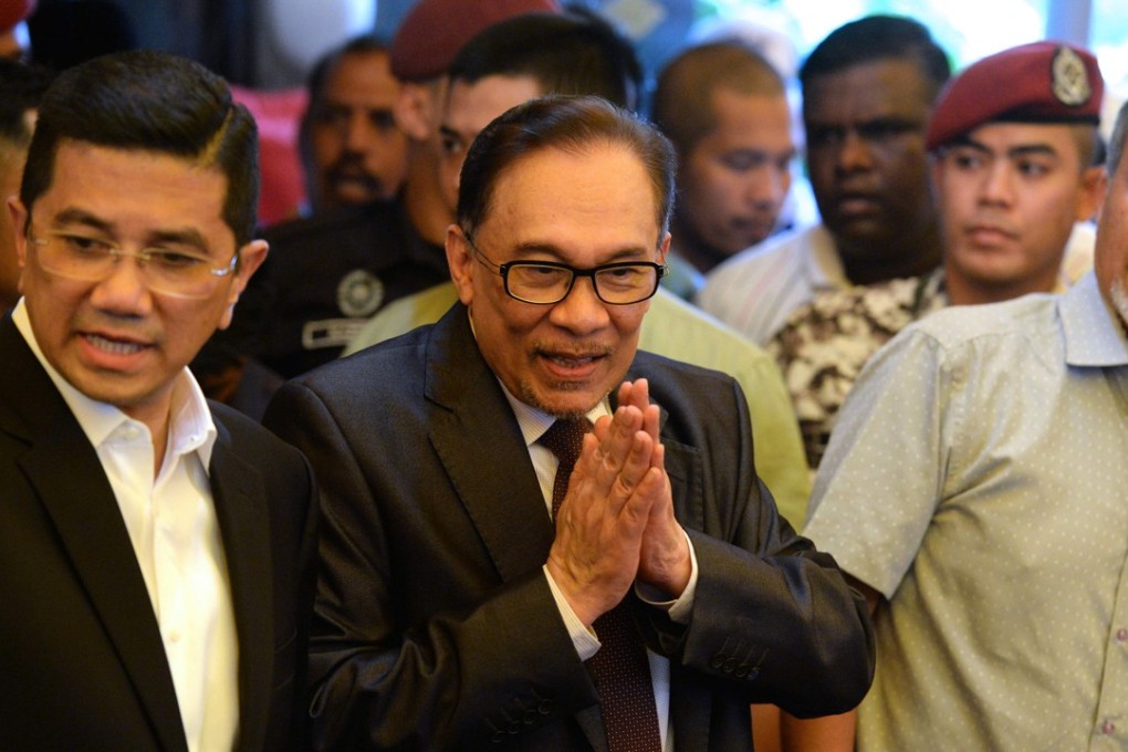Anwar Ibrahim speaks to the media after returning to his home following his release. Photo: AFP
