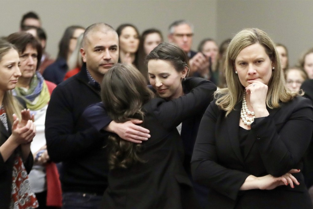 Former gymnast Rachael Denhollander (centre) is hugged after giving her victim impact statement during the seventh day of Larry Nassar's sentencing hearing in Lansing, Michigan, on January 24, 2018. Photo: AP