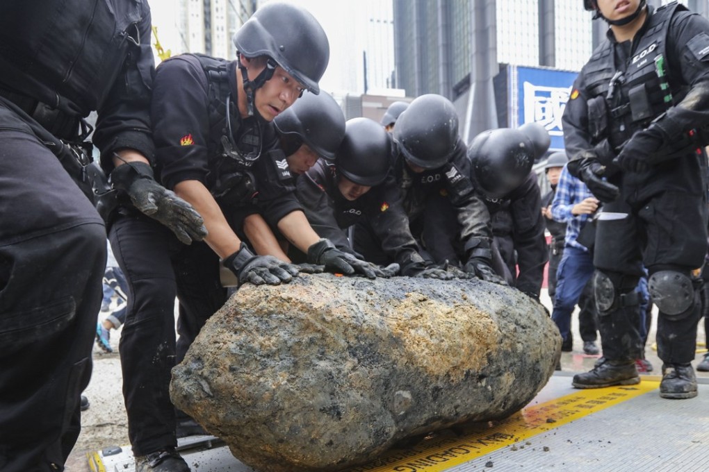 Members of the Hong Kong Police Force’s Explosive Ordnance Disposal Bureau defuse and remove the third wartime bomb found at the MTR’s Sha Tin-Central Link construction site, in Wan Chai on May 11. Photo: Felix Wong