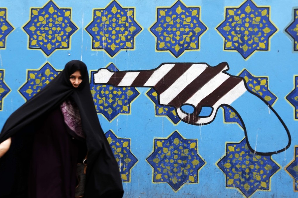 An Iranian woman walks past a mural on the wall of the former US embassy in the Iranian capital Tehran on May 8. Photo: Agence France-Presse