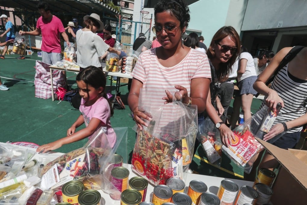 Parents and children volunteer to pack food bags for the needy, at Kennedy School in Pok Fu Lam on May 5. Photo: Jonathan Wong