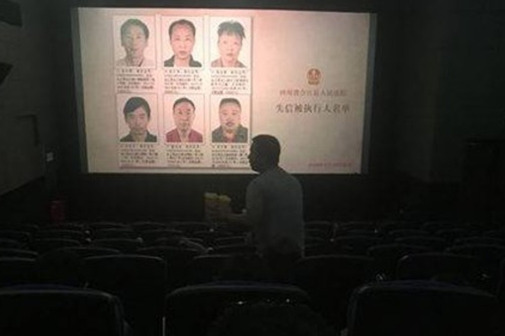 Details are flashed on a cinema screen of people who have defaulted on loans. Photo: Globaltimes.cn
